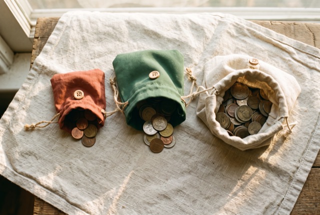 Coins divided into three cloth pouches of different sizes