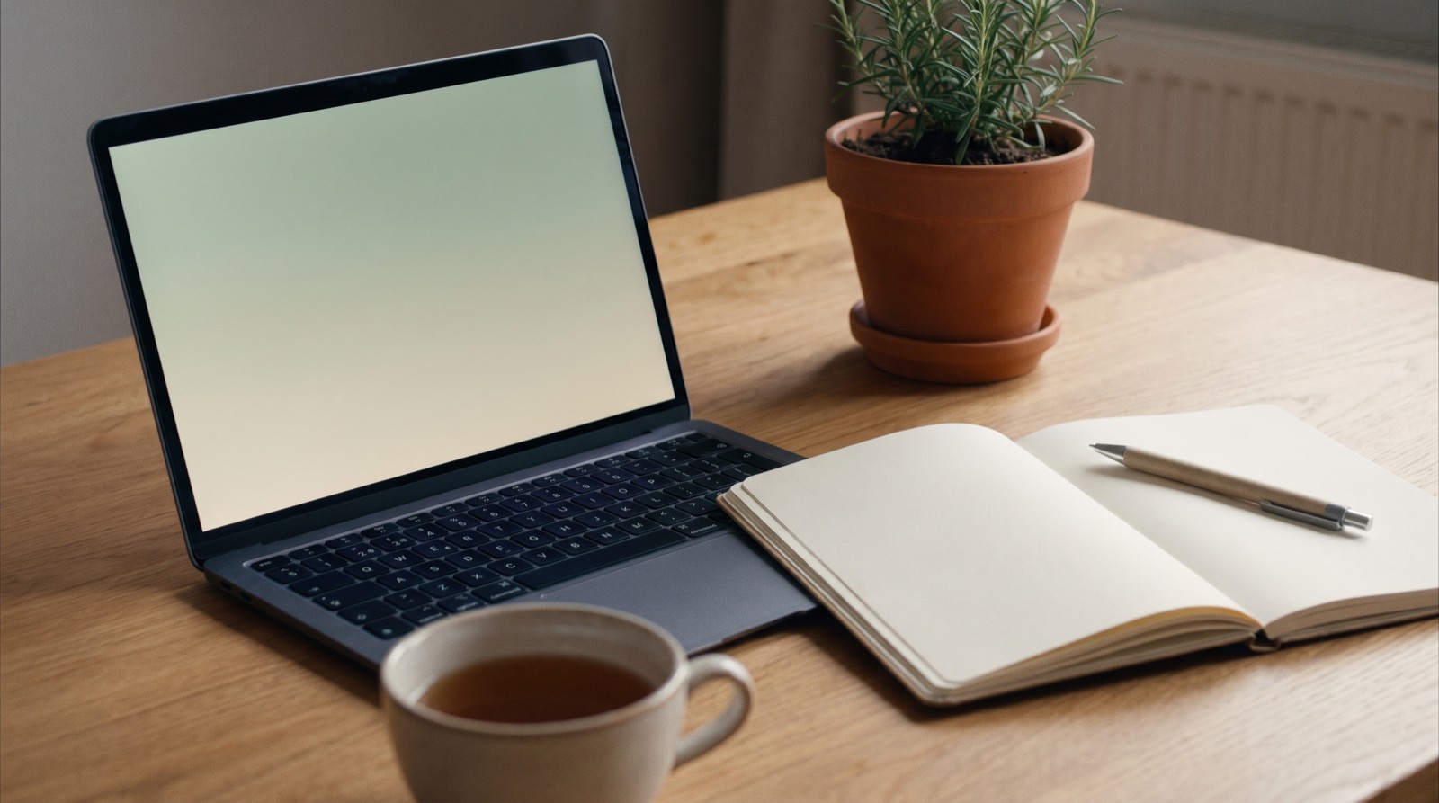A bright desk with a laptop and notebook