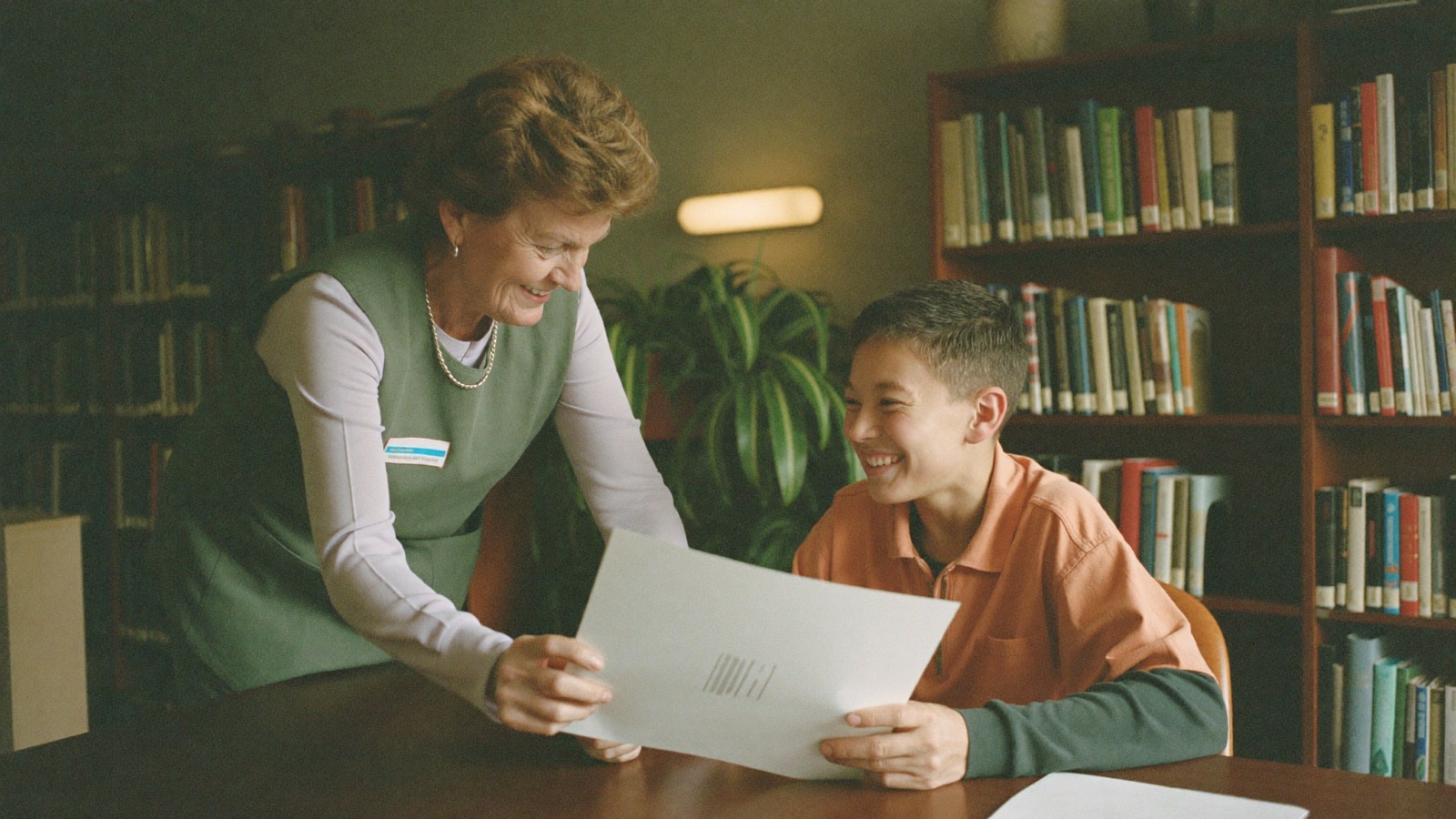 A community volunteer helping a visitor at a desk