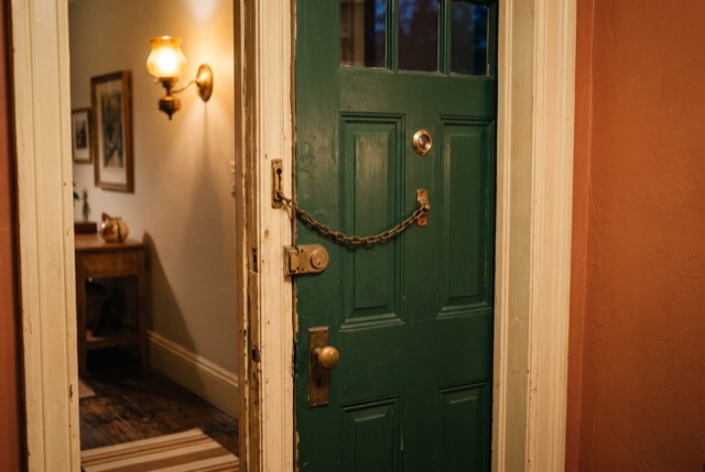A door chain engaged on a front door, seen from inside