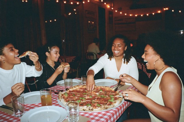 A family sharing pizza at a checkered table