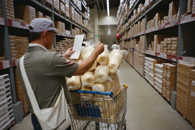 A flatbed cart in a tall warehouse aisle
