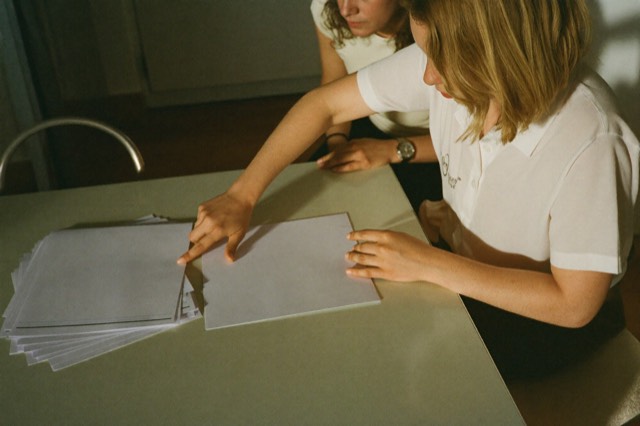 Two people reviewing paperwork over coffee