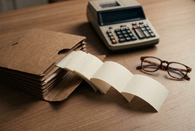 Receipts, a calculator and reading glasses