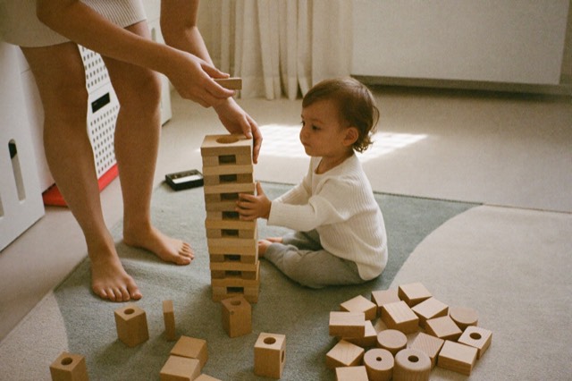 A toddler stacking wooden blocks